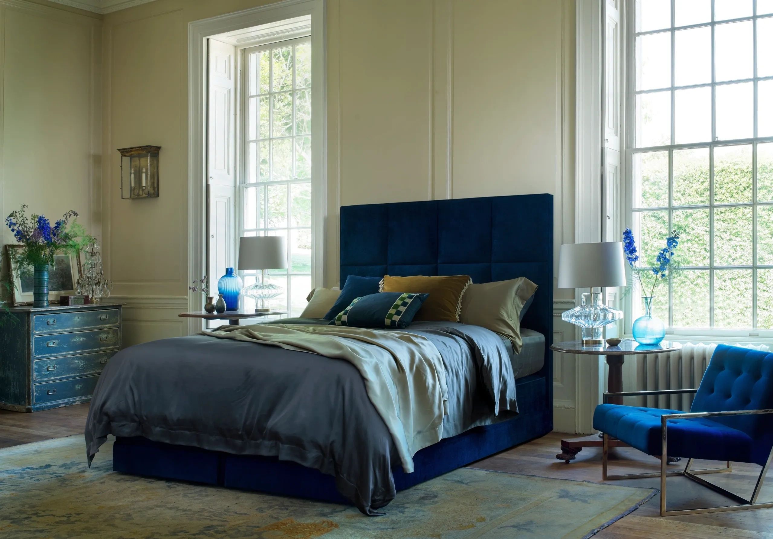 blue upholstered Hypnos divan bed dressed with linen bedding in a Georgian-styled bedroom