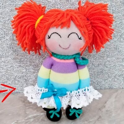 A red-headed sock doll with a happy smile.