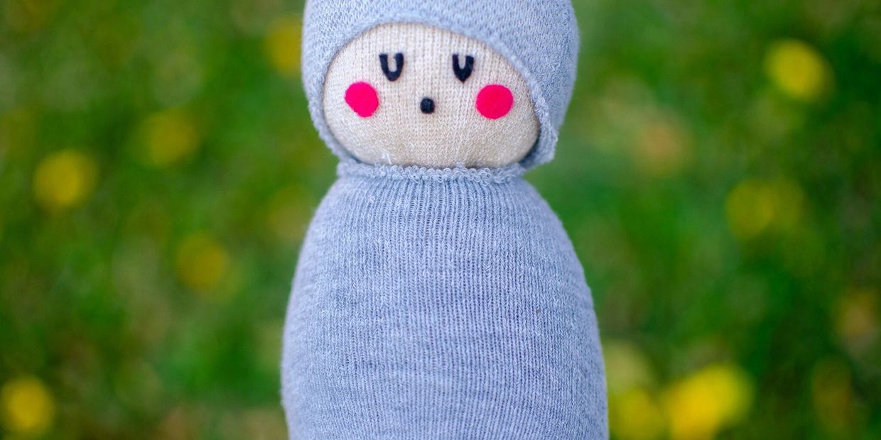 A sock doll looking like a baby sleeping