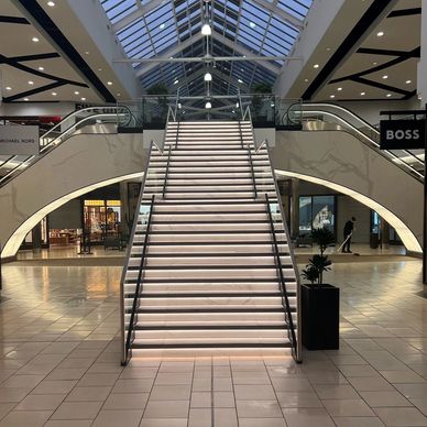 An image of a staircase at York Designer Outlet with LED's in the stairs, and tiled escalators