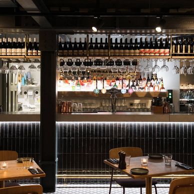 An image of a restaurant bar area with bespoke zinc bar top and tiled back bar. 