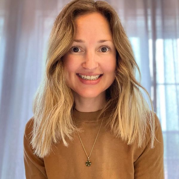 Smiling woman with blonde hair and a brown sweater.