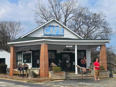Small town cafe with a few people outside on a clear day.