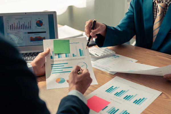 Hands holding financial data reports.