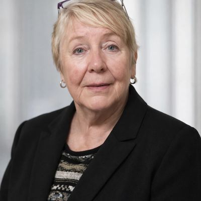 Smiling elderly woman in a black blazer.