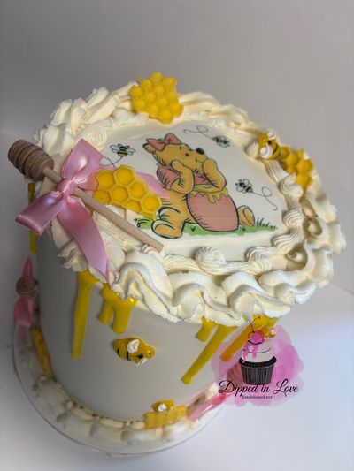 A Winnie the Pooh themed cake with honeycomb decorations and bees.