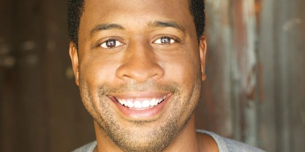 Smiling man with bright eyes and short hair.
