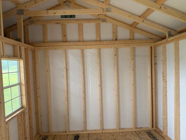 Interior of a wooden frame construction with window and plywood floor.