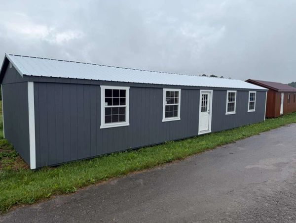 Long gray building with white windows and door.