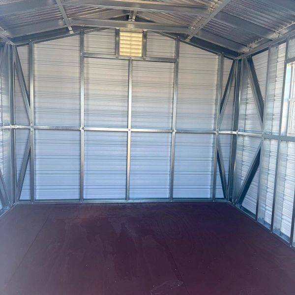 Empty metal shed interior with wooden floor.