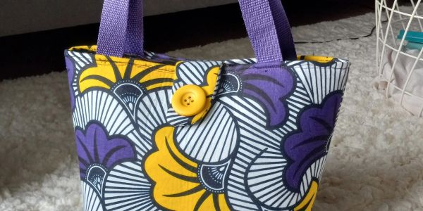 Colorful handbag with yellow and purple flowers.
