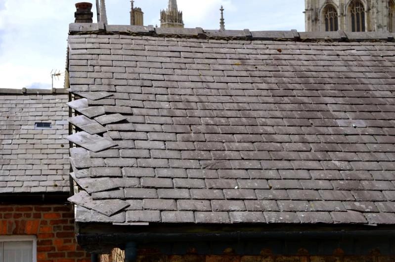 Image of slipped slates on grey slate roof from drone roof survey in York, Yorkshire, UK.