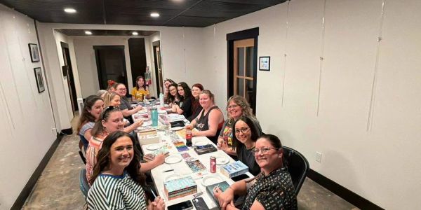 Group of people gathered around a long table in a meeting room.