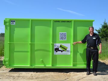 Man standing next to 20 yard dumpster