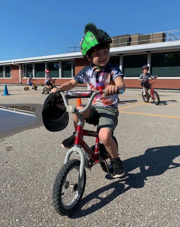 A child smiling and riding their bike.