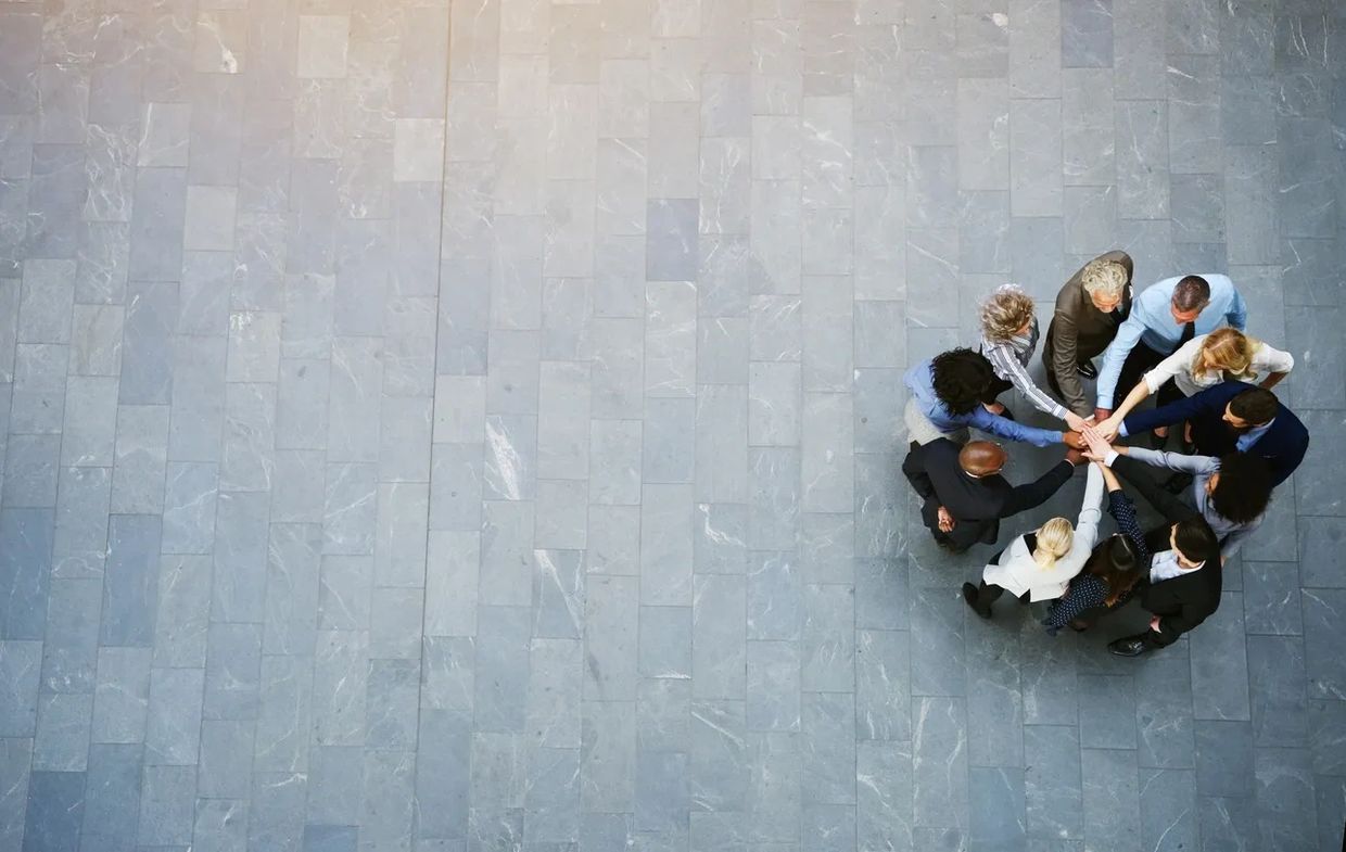 A Group of People Putting Hands Together as a Group