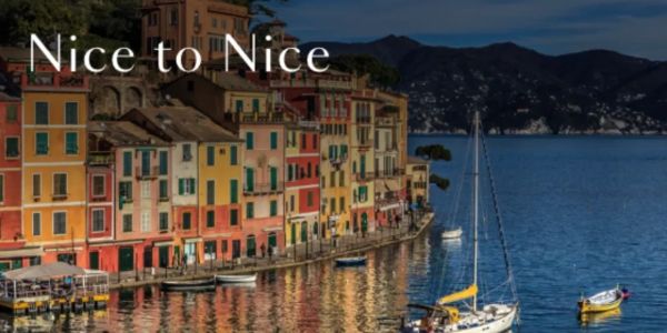 Colorful waterfront buildings with boats on calm water.