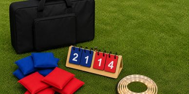 Cornhole game setup with bags, scoreboard, and carrying case on grass.