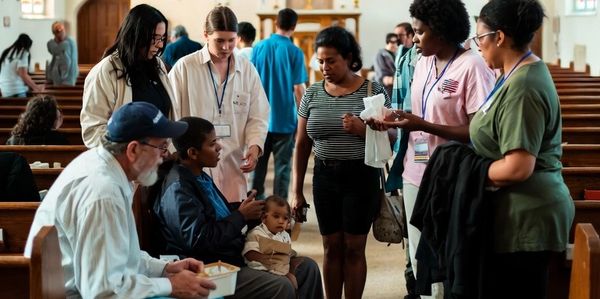 People gathered inside a church, engaging in conversation and support.