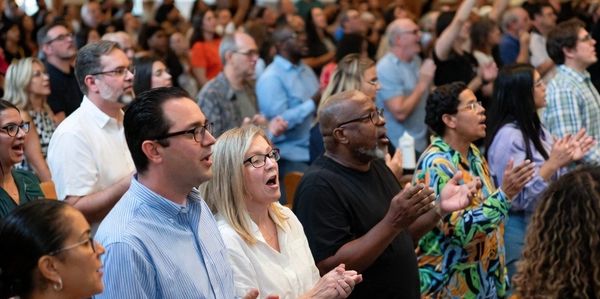 People gathered in a church, singing and worshiping together.