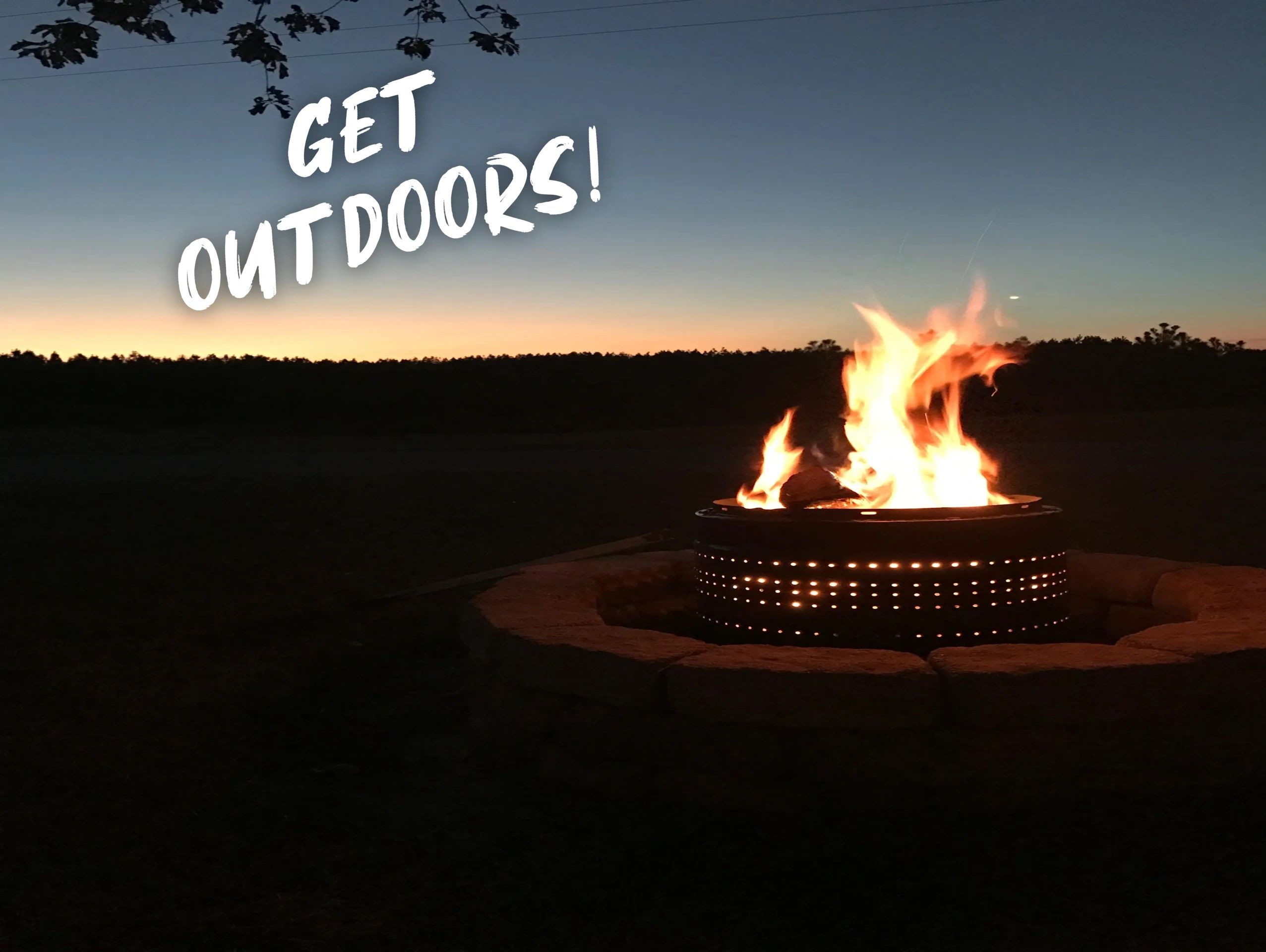 Flaming fire pit with sunset in the background