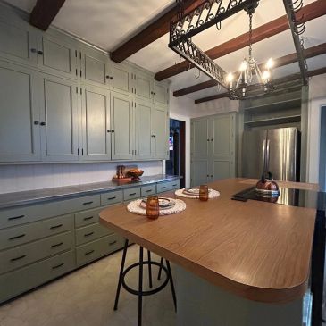 Cozy kitchen with wooden countertop and mint green cabinets.