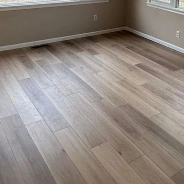 Empty room with wooden floor and beige walls.