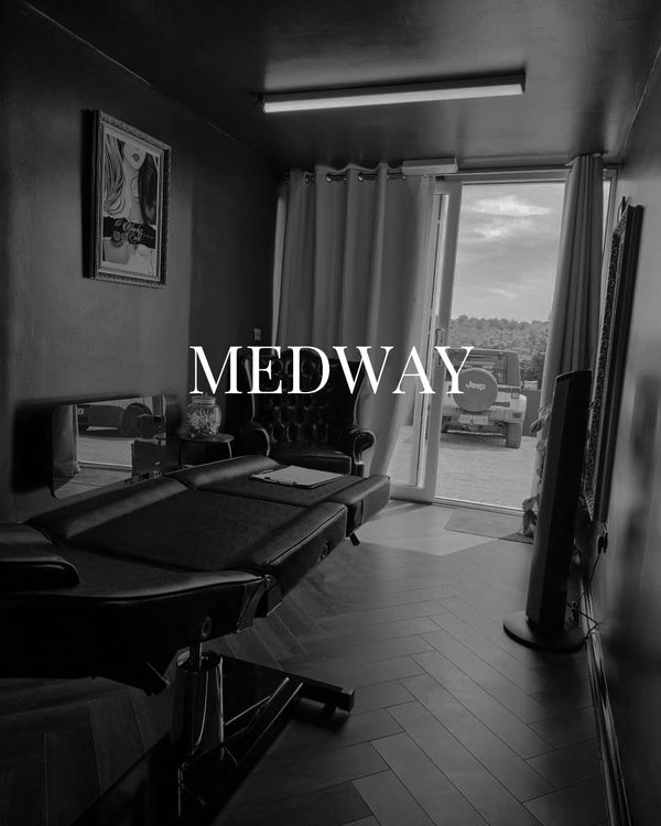Black and white interior of a clinic room with a treatment bed.