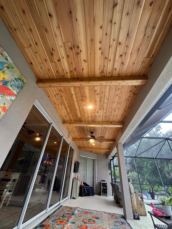 Cozy patio with wooden ceiling and sliding glass doors.