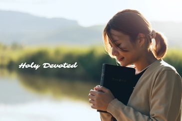 A woman carrying a bible by the shores of a lake, possibly praying
