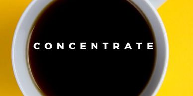A full coffee cup with the term “Concentrate” in the middle of the coffee. 