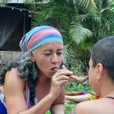 Two people sharing a moment outdoors, one feeding the other.
