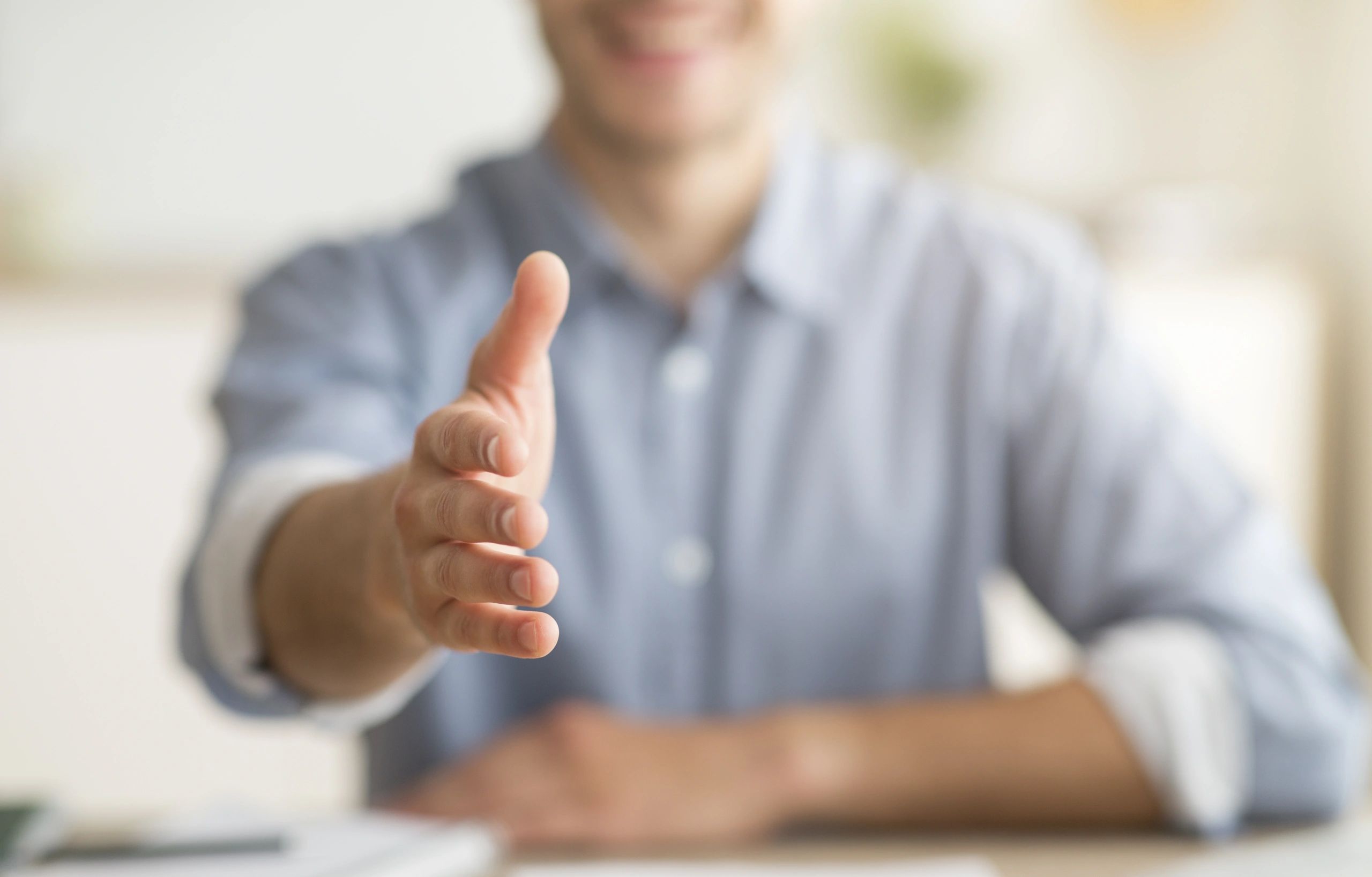 Professional man extending hand for a handshake.