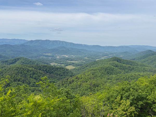 Lush green mountains under a partly cloudy sky.