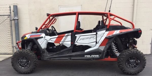 Polaris off-road side-by-side vehicle with red roll cage.