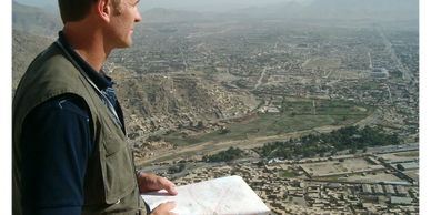 security person standing with map on a mountain in a hostile environment, depicting risk assessments