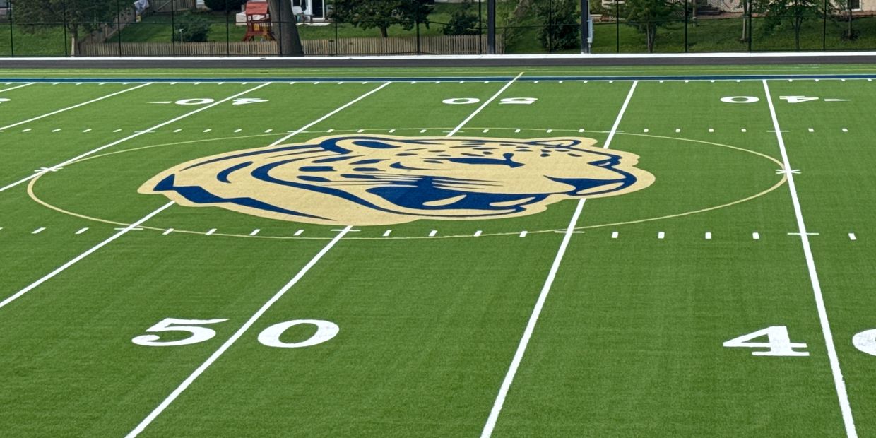 Football field with a tiger mascot at the center.
