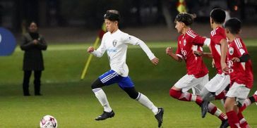 Soccer players chasing after Enzo trying to keep up