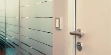 Modern office door with frosted glass and a card access control system.