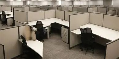 Empty office cubicles with chairs and desks.