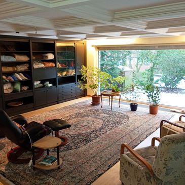 Cozy living room with large window, plants, and comfortable seating.