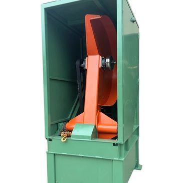 Green industrial machine with an orange component inside a protective housing.