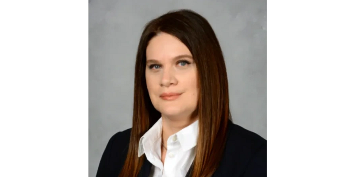 Professional woman with straight brown hair and a confident expression.