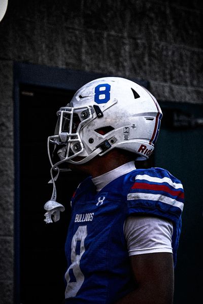 Football player in white helmet and blue jersey.