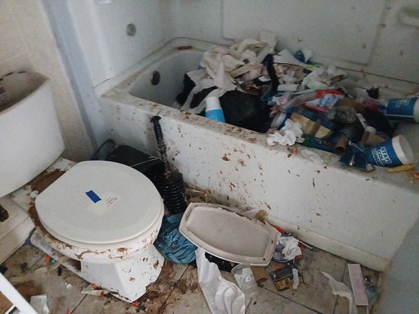 Bathroom filled with trash, feces, syringes. 