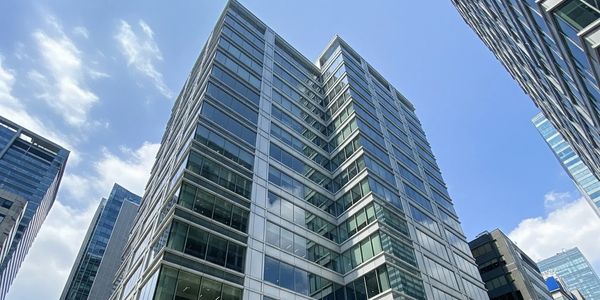 Modern office building with glass windows under a clear blue sky.