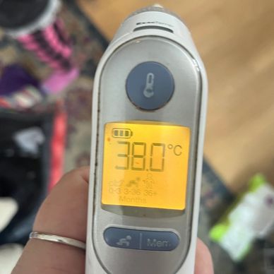 a close up of an ear thermommeter reading. 38. celsius