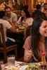 People smiling and chatting in a lively restaurant.