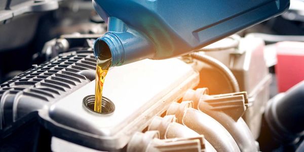 A person filling up engine oil