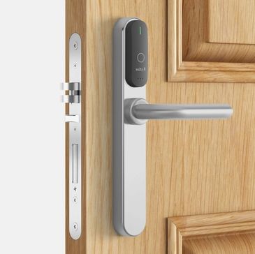 A picture of  neatly installed traditional style hotel door lock installed to a wooden door. 